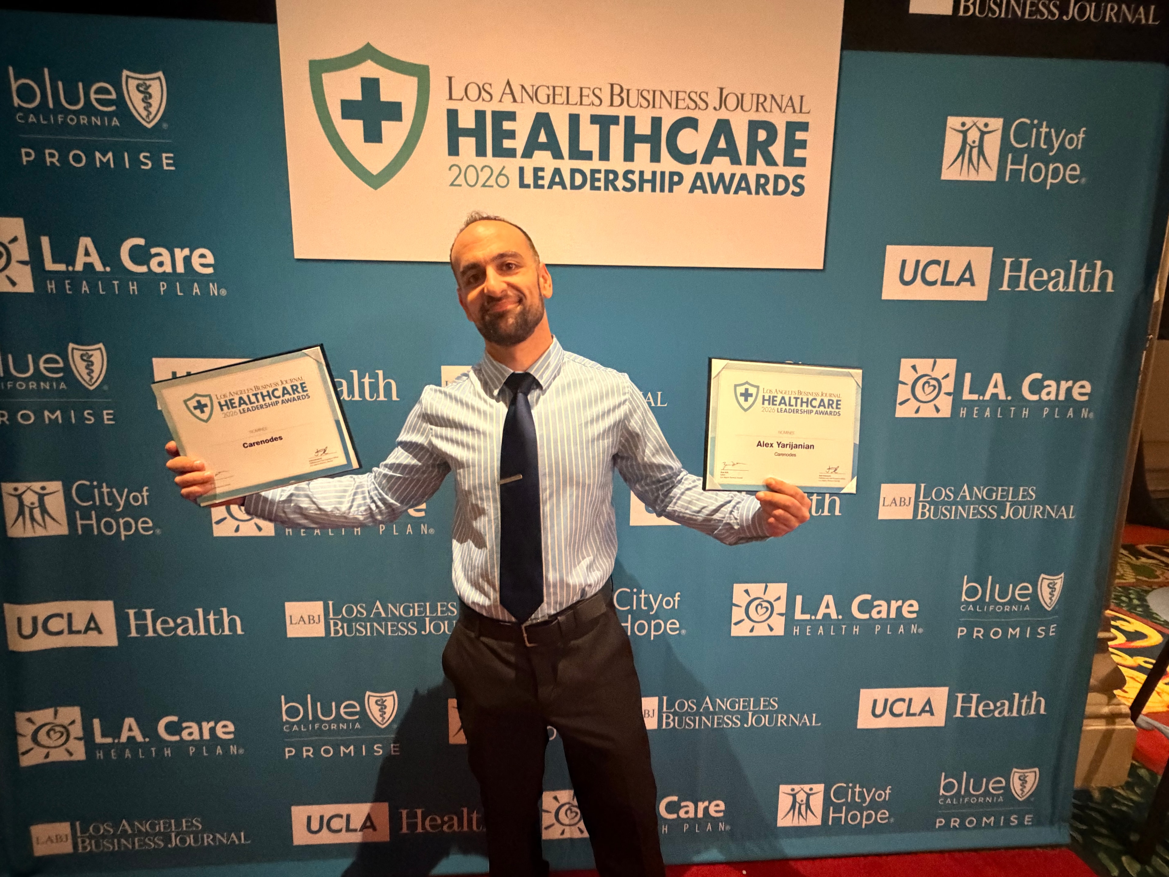 Alex Yarijanian holding Healthcare Leadership Award certificates